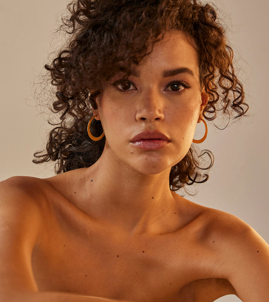 A Model Wearing Yellow 1 micron gold plated. Kyna Ear Hoops, curated by Only Ethikal