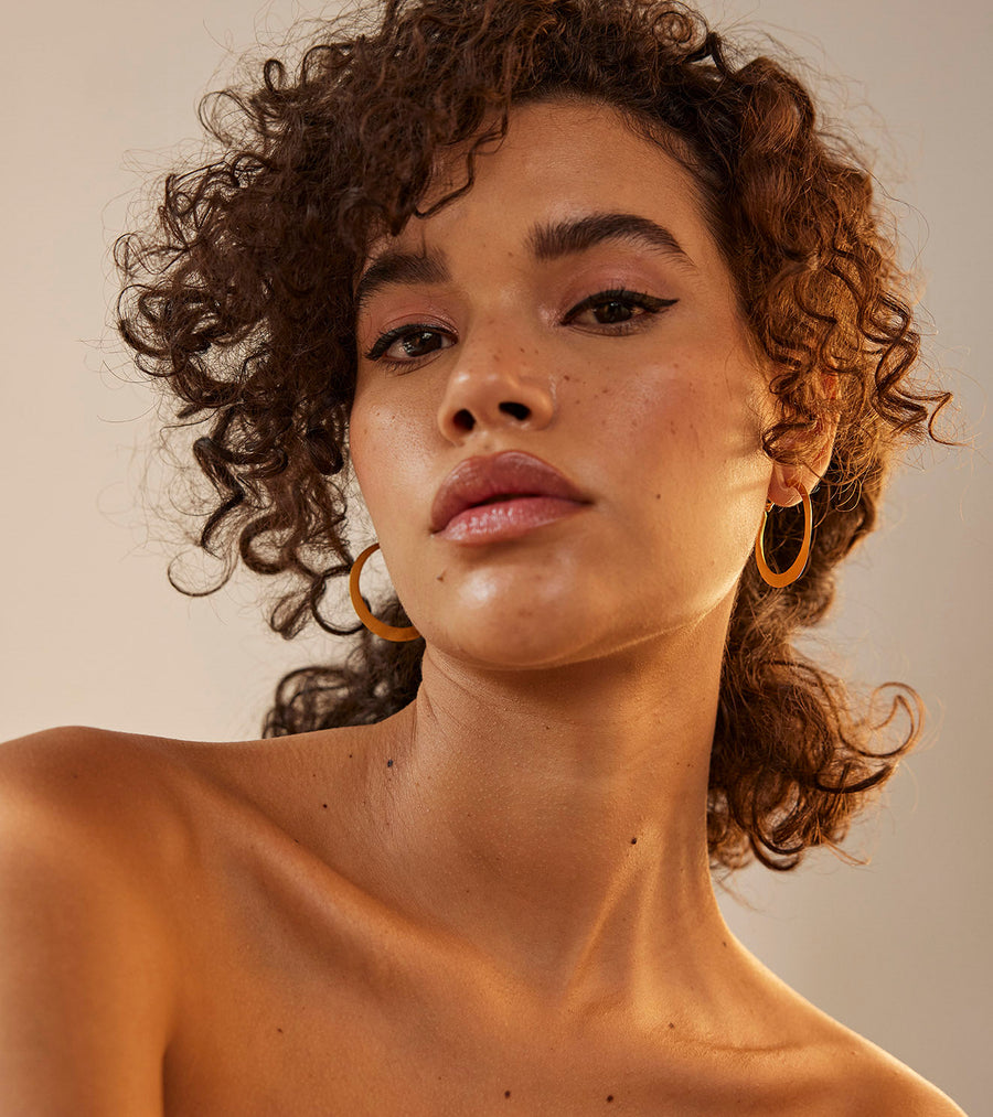 A Model Wearing Yellow 1 micron gold plated. Kyna Ear Hoops, curated by Only Ethikal